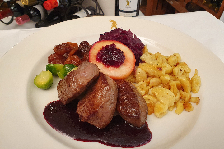 Rehschnitzel mit schwarzer Kirschsauce, hausgemachten Spätzli, braisiertem Rotkraut, glasierte Marroni, Rosenkohl und Preiselbeerapfel - Lapin