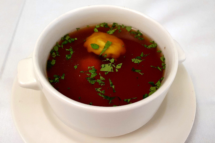 Wild Consommé mit Sherry, Gemüsestreifen und hausgemachter Pilzravioli - Lapin