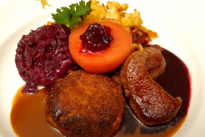 Duo vom Wild, Zartes Rehschnitzel und Wildhacktätschli mit schwartzer Kirsch und Wildrahmsauce, dazu hausgemachte Spätzli, braisiertem Rotkraut und Preiselbeerapfel - Lapin