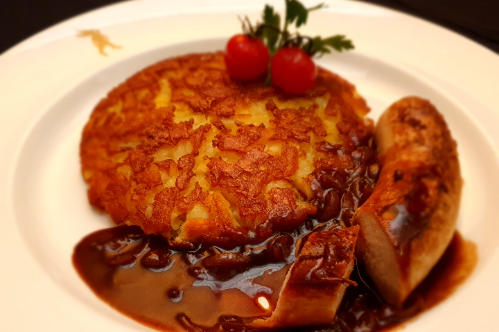 Kalbsbratwurst an Zwiebelsauce mit gluschtiger Butterrösti - Lapin